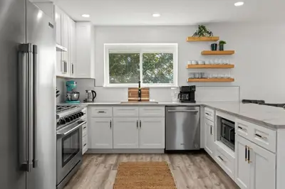 a kitchen with white cabinets and stainless steel appliances at Casa Del Palms - Private Pool Home, Game Room, 2 Min Walk to Beach, Pets OK! in Panama City Beach