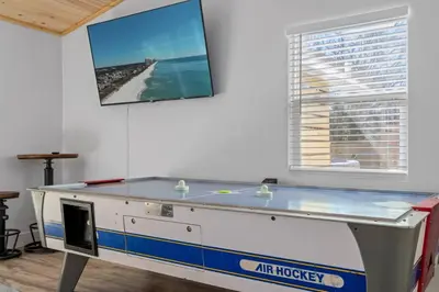 a ping pong table in a room next to a window at Casa Del Palms - Private Pool Home, Game Room, 2 Min Walk to Beach, Pets OK! in Panama City Beach