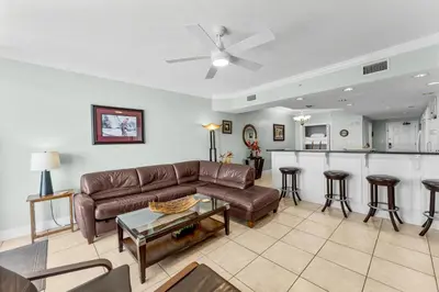 a living room with a couch and a bar at Treasure Island #1102 in Panama City Beach