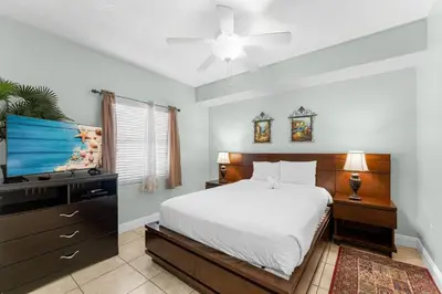 a bedroom with a bed and a flat screen tv at Treasure Island #1102 in Panama City Beach