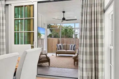 a screened in porch with a couch and chairs at Something Salty in Santa Rosa Beach