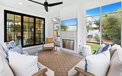 a living room with white furniture and large windows at Something Salty in Santa Rosa Beach