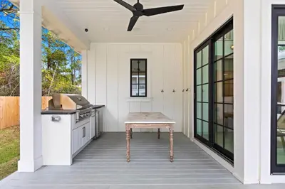 a patio with a table and a ceiling fan at Something Salty in Santa Rosa Beach