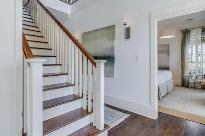 a staircase in a home with white walls and wood floors at Southern Breeze in Inlet Beach
