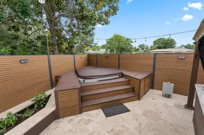 a hot tub sitting on a patio with a fence at Sandcastle House Hot Tub, OD Kitchen & Game Room! in Panama City Beach