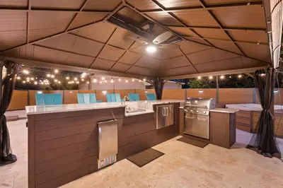 an outdoor kitchen with a bar and a stove at Sandcastle House Hot Tub, OD Kitchen & Game Room! in Panama City Beach