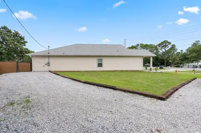 a house with a gravel driveway in front of it at Sandcastle House Hot Tub, OD Kitchen & Game Room! in Panama City Beach