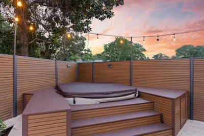 a bed sitting on top of a wooden deck at Sandcastle House Hot Tub, OD Kitchen & Game Room! in Panama City Beach