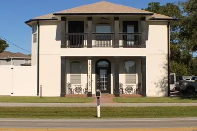 a large white house with a balcony on a street at Sandcastle House Hot Tub, OD Kitchen & Game Room! in Panama City Beach