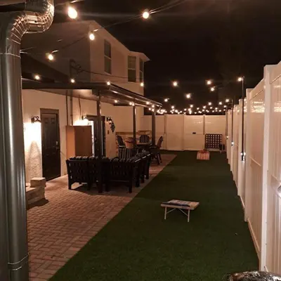 a patio with benches and a table and lights at Vibrant NewOrleans style retreat in Panama City Beach