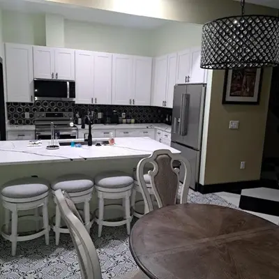 a kitchen with a large island with chairs and a table at Vibrant NewOrleans style retreat in Panama City Beach