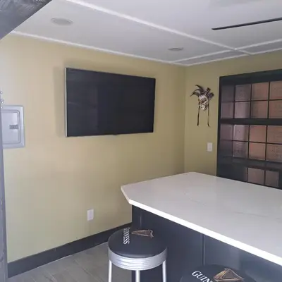 a kitchen with a counter and a tv on the wall at Vibrant NewOrleans style retreat in Panama City Beach