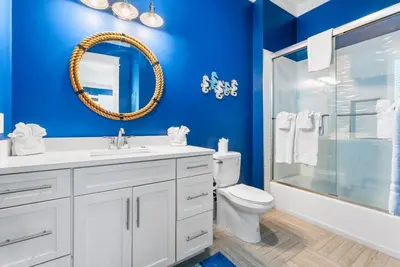 a blue bathroom with a toilet and a shower at Breezin at 19406 FBR in Panama City Beach