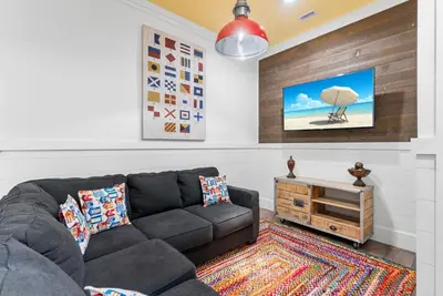 a living room with a couch and a tv at Breezin at 19406 FBR in Panama City Beach