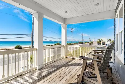 a wooden porch with a bench and the ocean at Breezin at 19406 FBR in Panama City Beach