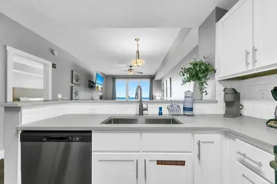 a white kitchen with a sink and a dishwasher at Calypso 3-1107 in Panama City Beach