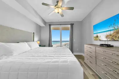 a bedroom with a bed and a ceiling fan at Calypso 3-1107 in Panama City Beach
