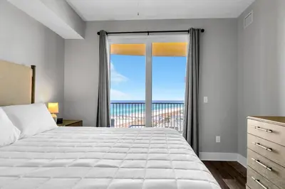 a bedroom with a bed and a large window at Calypso 3-1107 in Panama City Beach