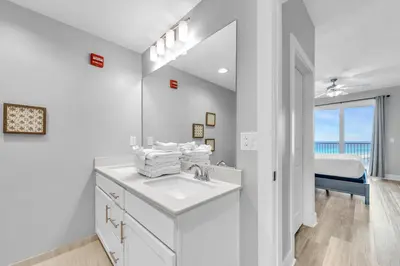 a white bathroom with a sink and a mirror at Calypso 3-1107 in Panama City Beach