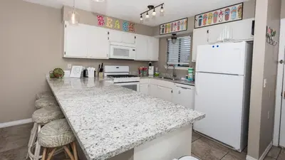 a kitchen with white cabinets and a white refrigerator at 2 BD 2 and half BA Two Story Beach Haven Pet Friendly with Golf Cart in Panama City Beach