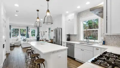 a kitchen with white cabinets and a white counter top at Best of Both Worlds in Santa Rosa Beach