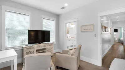 a living room with a tv and a table and chairs at Best of Both Worlds in Santa Rosa Beach