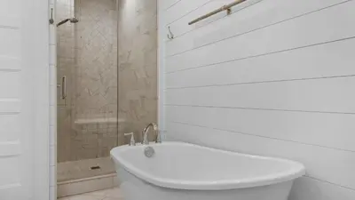 a white bathroom with a toilet and a shower at Best of Both Worlds in Santa Rosa Beach