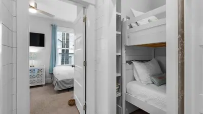 a bedroom with a bunk bed and a bedroom with a tv at Best of Both Worlds in Santa Rosa Beach
