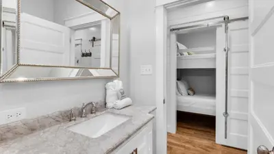 a white bathroom with a sink and a mirror at Best of Both Worlds in Santa Rosa Beach