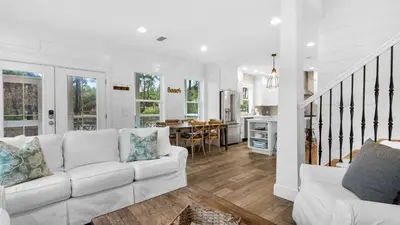 a living room with a white couch and a table at Best of Both Worlds in Santa Rosa Beach