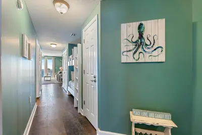 a hallway with an octopus painting on a blue wall at 1004 Seychelles in Panama City Beach