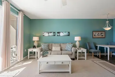 a living room with blue walls and a couch at 1004 Seychelles in Panama City Beach