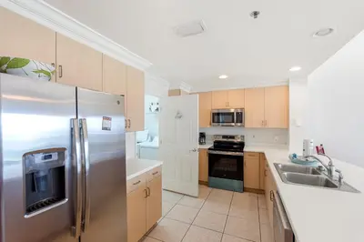 a kitchen with stainless steel appliances and wooden cabinets at 1005 Sterling Beach in Panama City Beach