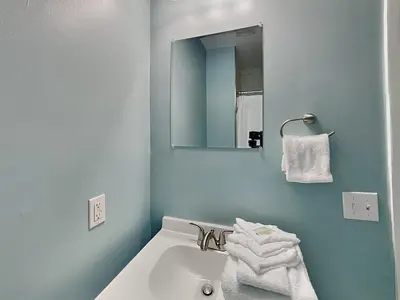 a bathroom with a sink and a mirror and towels at PC Beach Retreat D in Panama City Beach