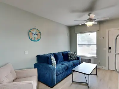 a living room with a blue couch and a table at PC Beach Retreat D in Panama City Beach