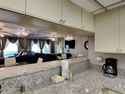 a kitchen counter with a sink and a living room at Edgewater Villa #2005 in Panama City Beach