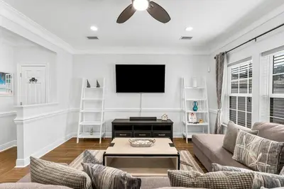 a living room with a couch and a flat screen tv at Beach House - Sunset Escape by Panhandle Getaways in Panama City Beach