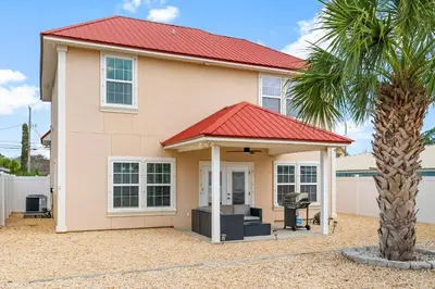 a house with a red roof and a palm tree at Beach House - Sunset Escape by Panhandle Getaways in Panama City Beach
