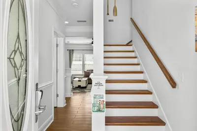 a staircase in a home with white walls and wood floors at Beach House - Sunset Escape by Panhandle Getaways in Panama City Beach