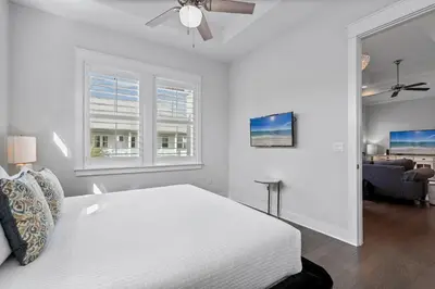 a white bedroom with a bed and a ceiling fan at The Anchorage in Inlet Beach