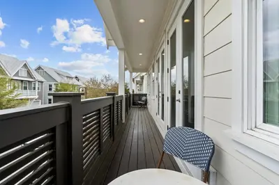 a balcony with a table and chairs on a house at The Anchorage in Inlet Beach
