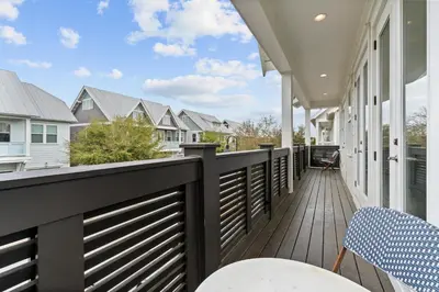 a balcony with tables and chairs on a house at The Anchorage in Inlet Beach
