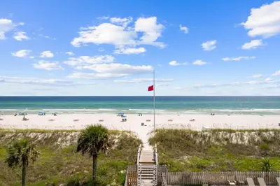 a view of a beach with a red flag at Ramsgate Harbour #16 by 30A Escapes in Panama City Beach