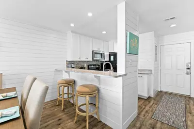 a kitchen with a counter and stools in a room at Ramsgate Harbour #16 by 30A Escapes in Panama City Beach