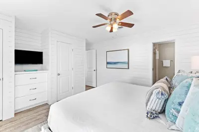 a white bedroom with a bed and a ceiling fan at Ramsgate Harbour #16 by 30A Escapes in Panama City Beach