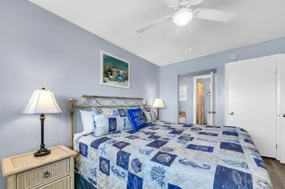 a bedroom with a bed and a ceiling fan at The Summit 1019-Toes in the Sand in Panama City Beach