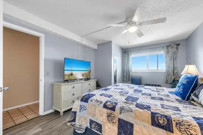 a bedroom with a bed and a flat screen tv at The Summit 1019-Toes in the Sand in Panama City Beach