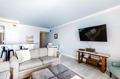 a living room with a couch and a flat screen tv at Breathtaking gulf-front condo near Pier Park in Panama City Beach