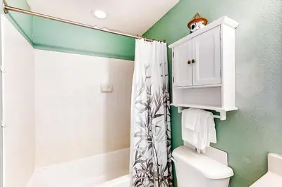 a bathroom with a white cabinet and a shower at Breathtaking gulf-front condo near Pier Park in Panama City Beach