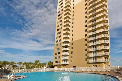 a building with a swimming pool in front of a building at Breathtaking gulf-front condo near Pier Park in Panama City Beach